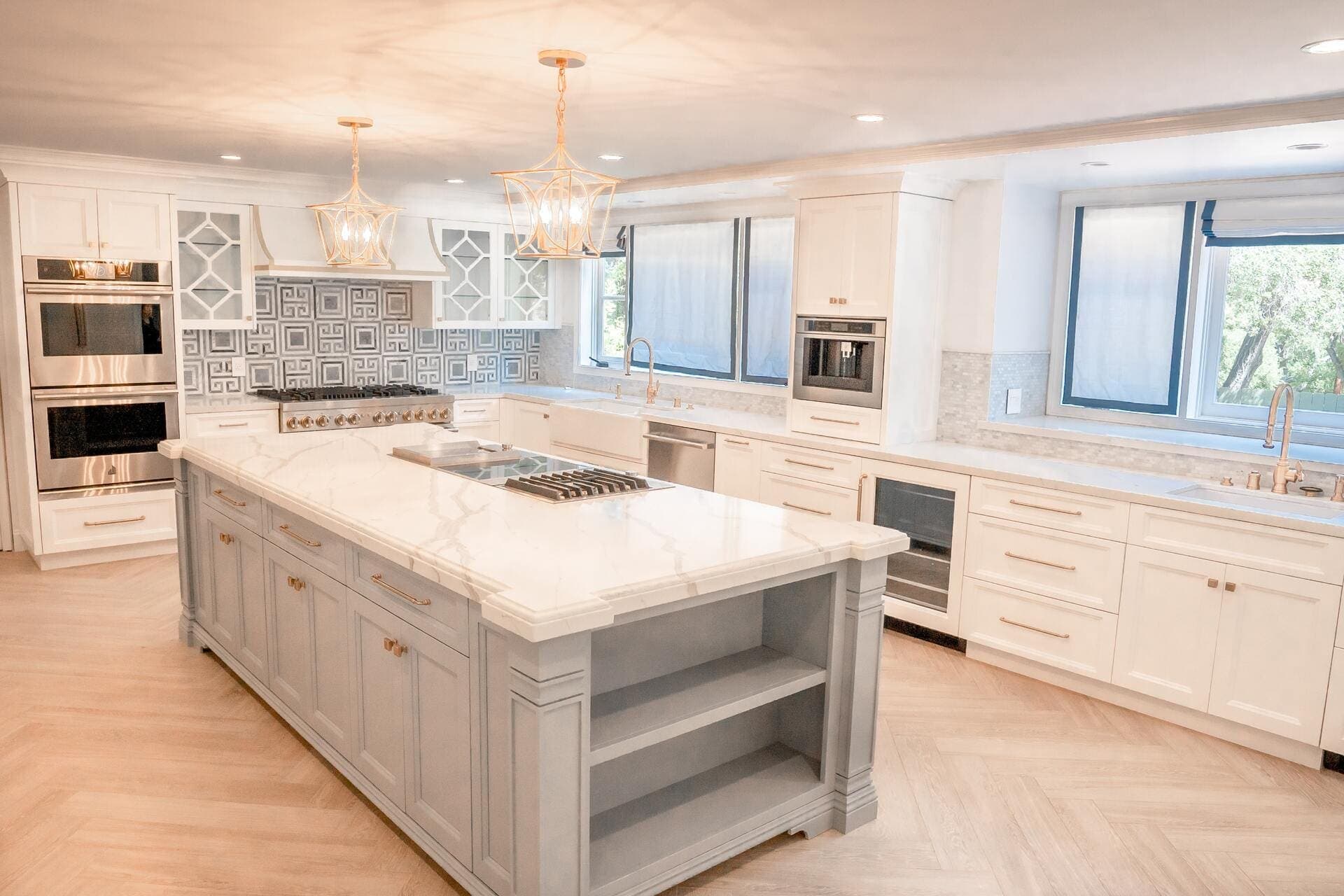 White kitchen with a marble-topped island and shaker cabinets